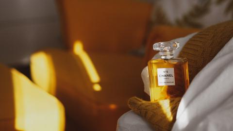 Happy woman enjoying perfume aroma Woman in ponytail	Woman testing perfume with joy Man in sunglasses	Stylish man representing luxury fragrance Candle + perfume bottle	Luxury perfume bottle with warm lighting